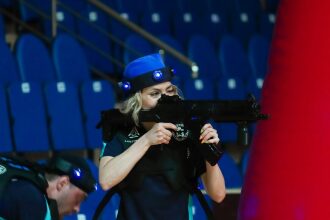 Девушка LASERWAR в синей кепке целится из оружия.